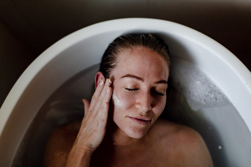 Woman applying a mask in a bath. 